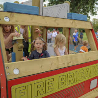 Rollenspiele – Kinder in einer Spielanlage in Form eines Feuerwehrautos von eibe