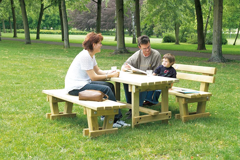 Außenmöbel für Schulen – Eltern sitzen mit ihrem Sohn in einer Sitzgruppe bestehend aus zwei Bänken mit Tisch.