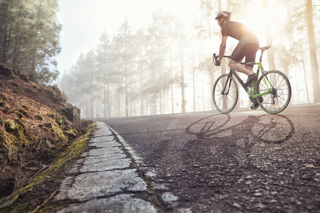 Ausdauertraining – Ausdauersport stärkt die Herzmuskulatur und den Kreislauf. Beschreibung: Ein Mann in Sportbekleidung fährt Fahrrad.