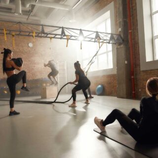 Zirkeltraining – Fünf Sportler und Sportlerinnen beim Zirkeltraining im Fitnessstudio.